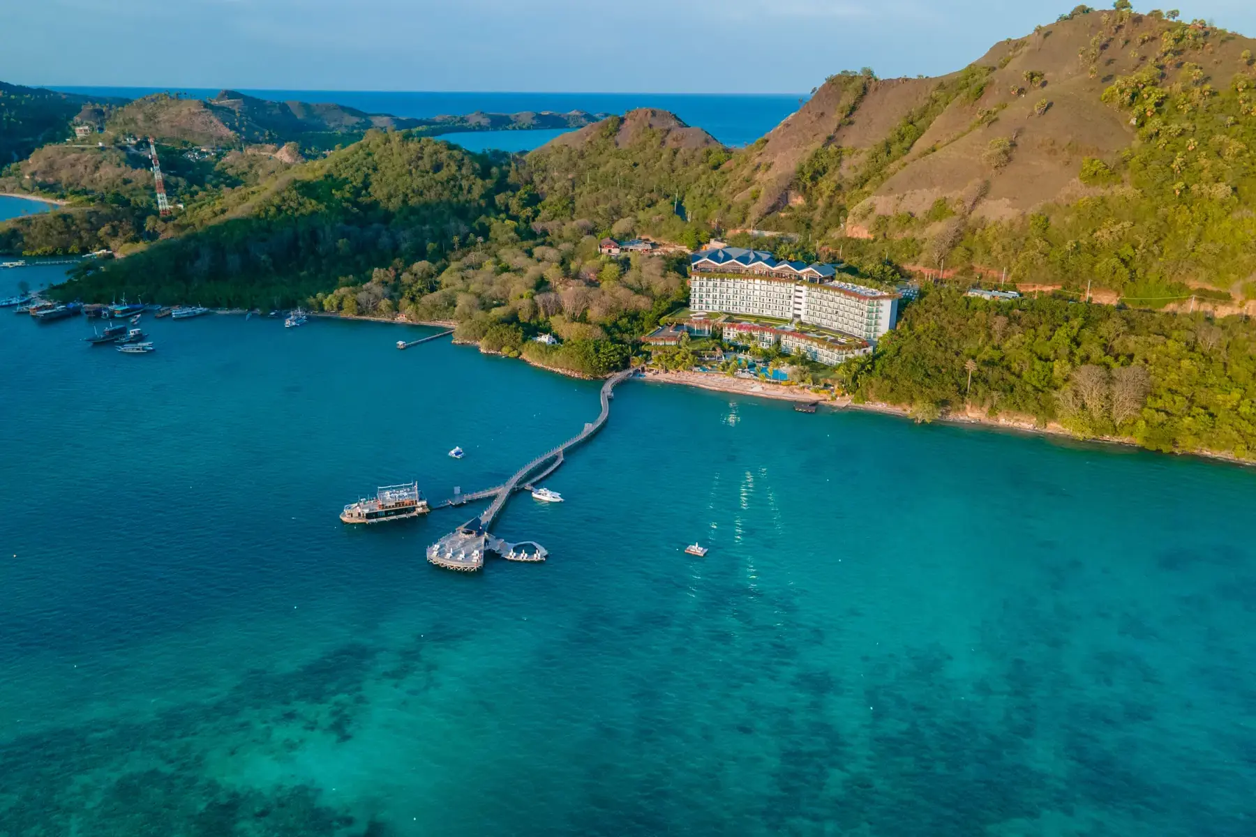 海湾锚地 —— 船宿船停在湾内，岸上是绿丘与栈桥码头